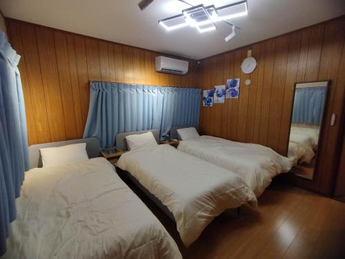 东京HIDAKA STAY VILLA 柴又的木镶板客房内的两张床