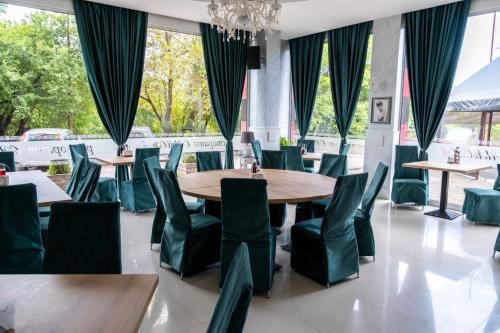 索非亚西蒙娜艺术酒店的用餐室配有桌子和绿色椅子