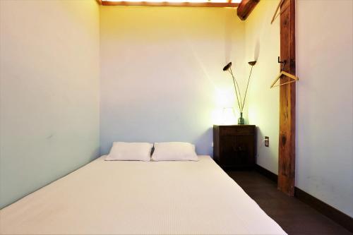 首尔NagNe House Boutique Hanok的卧室配有白色的床和桌子