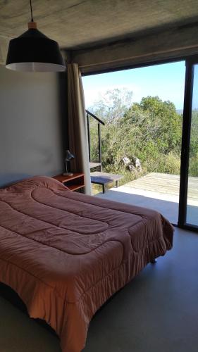 塞拉纳镇Gran Vista y Tranquilidad的一间卧室设有一张床和一个大窗户