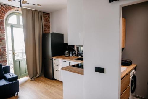 罗兹VS Apartments - apartament nr 34的厨房配有黑冰箱和白色橱柜。