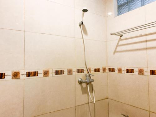 日惹Musafira Hotel Syariah Malioboro Yogyakarta Mitra RedDoorz的浴室内配有淋浴和头顶淋浴