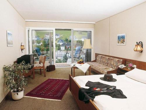 施马伦贝格Gasthof Heimes的一间带两张床的房间和一个带沙发的客厅