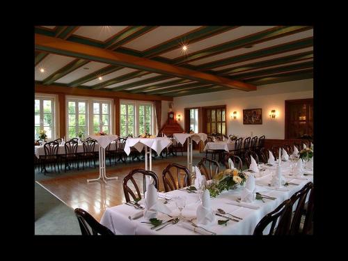 施马伦贝格Gasthof Heimes的配有桌椅和白色桌布的房间