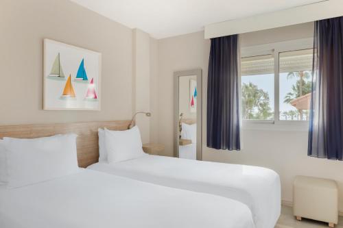 卡拉德米哈斯洛斯阿米戈斯海滩俱乐部钻石度假酒店的一间卧室设有两张床和窗户。