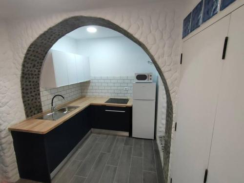 普雷塔斯Casa Paula的厨房设有水槽和冰箱,配有拱门