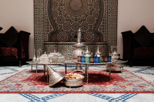 非斯Riad Dar Laura的客厅配有2张桌子和地毯