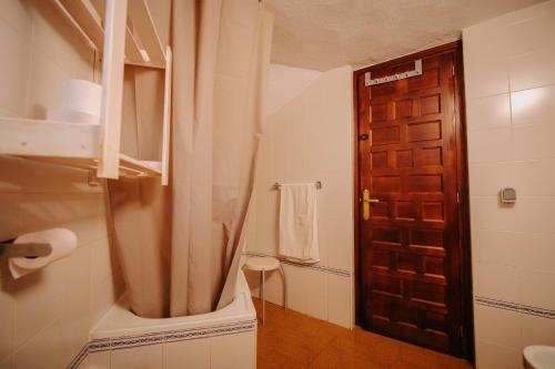 贝瑙卡斯罗斯克索斯度假屋的一间带卫生间和木门的浴室