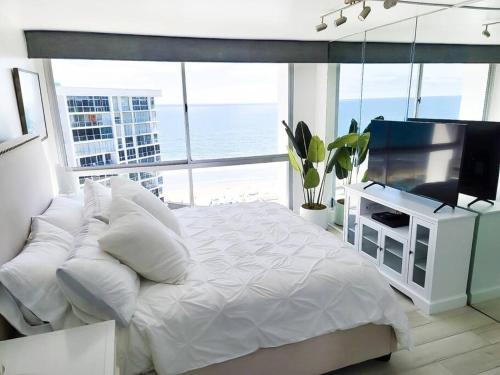 圣地亚哥Luxury Beach-Front High-Rise Apartment的卧室配有白色的床和电视。