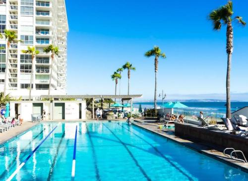 圣地亚哥Luxury Beach-Front High-Rise Apartment的一座棕榈树游泳池和一座建筑