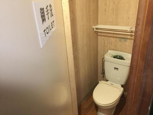 千曲市卡梅西日式旅馆的一间小浴室,内设卫生间和墙上的标志