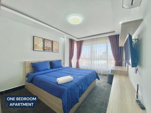 金边WH Chamkarmon Residence的一间卧室配有一张带蓝色床单的床和电视。