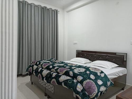达兰萨拉RADHA BNB ( HOMESTAY )的一间卧室配有一张带被子和枕头的床