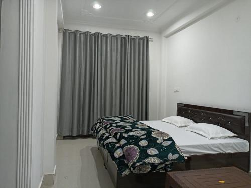 达兰萨拉RADHA BNB ( HOMESTAY )的一间卧室设有一张床和一个窗口