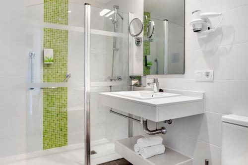 卡门港卡门俱乐部钻石度假村的白色的浴室设有水槽和淋浴。