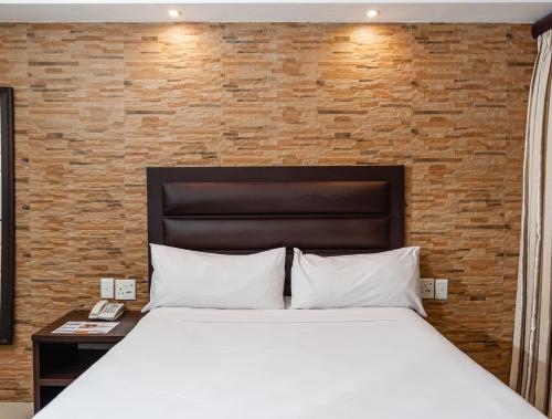 德班Bayside Hotel & Self Catering 110 West Street的一间卧室设有一张床和砖墙