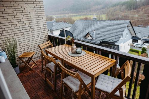 温特贝格Ferienwohnung mit Seeblick — Sport und Erholung的阳台上的木桌和椅子