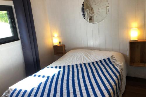 波尔尼谢Charming House In Pornichet Near The Beach的一间卧室配有一张带蓝白条纹毯子的床