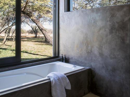 Dinokeng Game ReserveNAKO Safari Lodge的带浴缸的浴室和窗户
