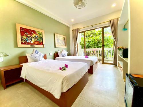 会安DE VIVRE HOI AN - Aman Boutique Hotel的酒店客房设有两张床和电视。