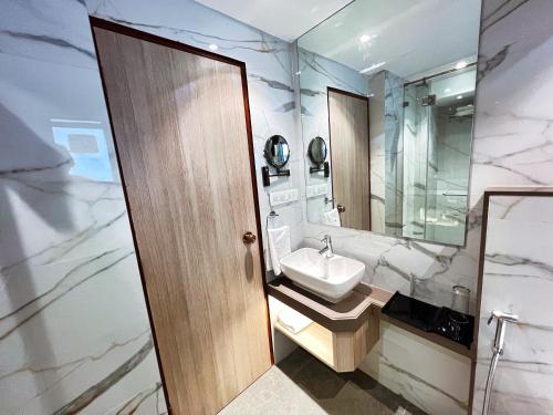 孟买White House by Maxxvalue Service Apartments Bandra的浴室设有白色水槽和镜子