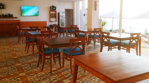 圣吉吉阿亚古纳别墅旅馆的用餐室配有木桌和椅子