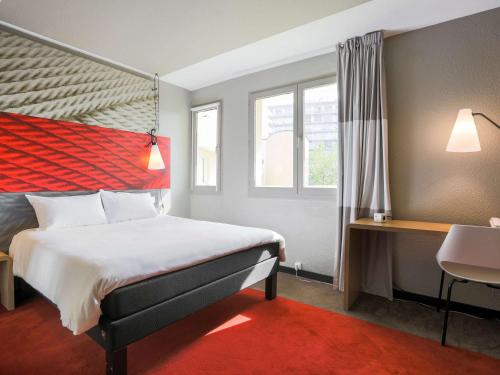 圣艾蒂安Ibis Saint Étienne - La Terrasse的酒店客房设有床和窗户。