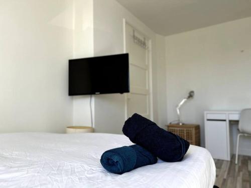 埃因霍温Room 505 - Eindhoven by T&S的一张铺在床上的蓝色毛巾,带一台电视机
