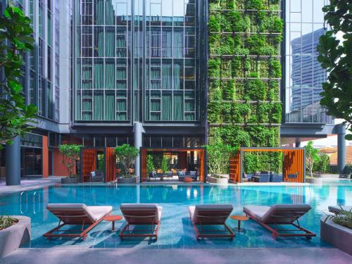 新加坡Pullman Singapore Hill Street的一座带椅子和建筑的大型游泳池