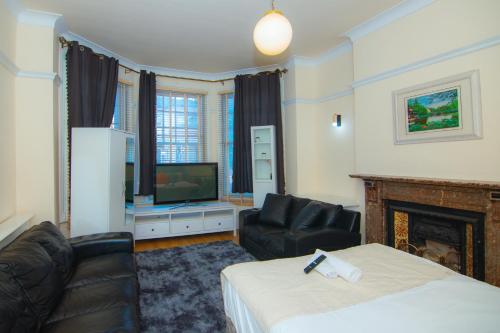 伦敦Victorian Woods BnB的酒店客房,配有床和电视