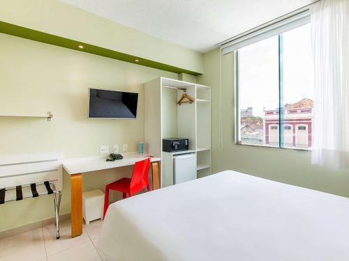 马瑙斯马瑙斯高旅馆的配有一张床、一张书桌和一扇窗户的酒店客房
