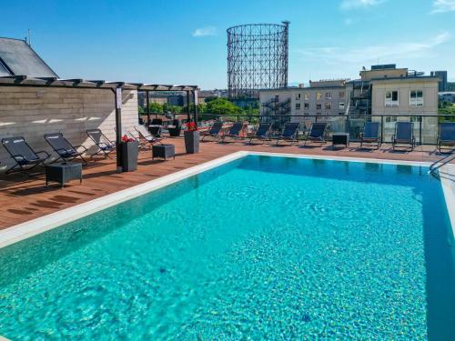 罗马H10罗马西塔酒店的建筑物屋顶上的游泳池