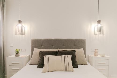 塞维利亚Avanti Murillo, Elegance & Comfort的一间白色卧室,配有一张带两个吊灯的床