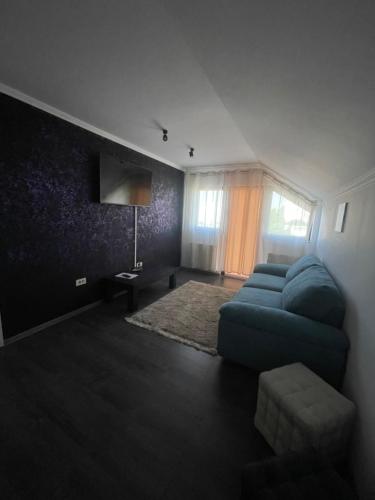 苏恰瓦Sara’S Apartament的客厅设有蓝色的沙发和窗户。