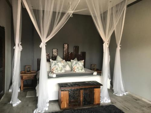MababeMababe River Lodge & Campsite的一间卧室配有带窗帘的天蓬床