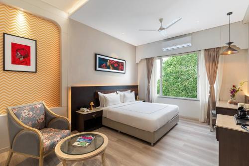 乌代浦City Connect by Downtown Udaipur的配有一张床和一把椅子的酒店客房