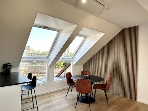 卡尔斯鲁厄Stylisches Apartment in zentraler Lage - mit Klima的一间带桌椅和窗户的用餐室