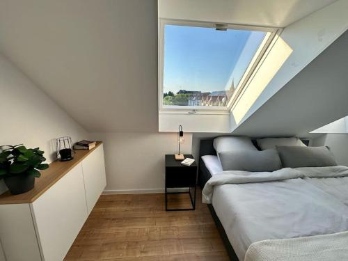 卡尔斯鲁厄Stylisches Apartment in zentraler Lage - mit Klima的一间卧室设有一张床和一个窗口