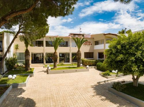 尼福雷伊卡宝林海滩酒店的一座棕榈树和庭院的建筑