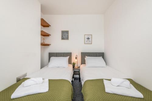 凯特林Wood House - 5 Beds, Suitable for contractors的白色墙壁客房的两张床