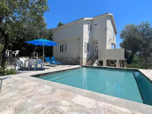 卢什蒂卡Villa Olive Tree with Private Pool的一座带遮阳伞的房屋前的游泳池