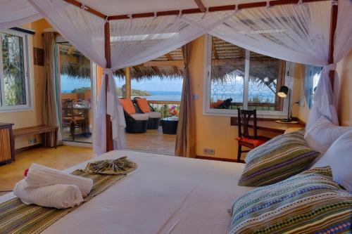 贝岛VILLA PANORAMA NOSY BE的一间卧室设有一张床,享有海景