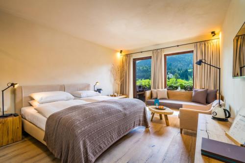 阿亨基希Posthotel Achenkirch Resort and Spa - Adults Only的一间卧室配有一张大床和一张沙发