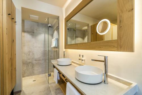 阿亨基希Posthotel Achenkirch Resort and Spa - Adults Only的一间带两个盥洗盆和淋浴的浴室