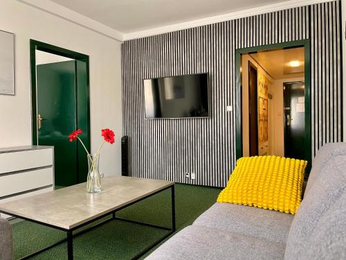布尔诺A-奥斯特里茨酒店的客厅配有沙发和带花卉的花瓶
