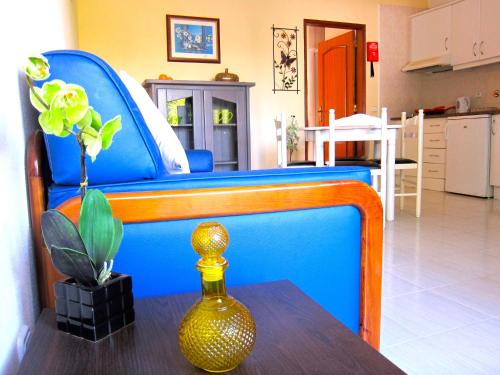 阿尔布费拉Casa da Horta, Vale carro Olhos de Agua的一张蓝色的床,桌子上放着花瓶