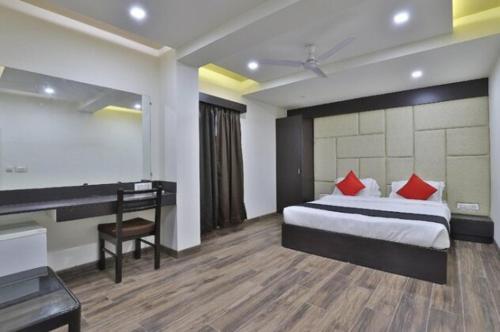 甘德希罕Hotel Grand Ambience的酒店客房配有一张床、一张书桌和一张书桌。