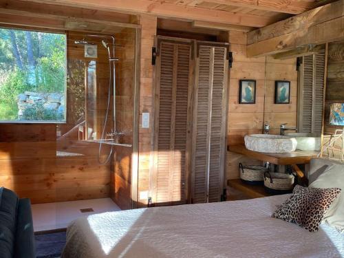 卡西斯logement entier atypique à Cassis的一间卧室配有一张床,浴室设有水槽