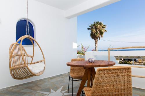 安提帕罗斯岛KAMEO, Antiparos的一间设有藤制秋千和桌椅的房间