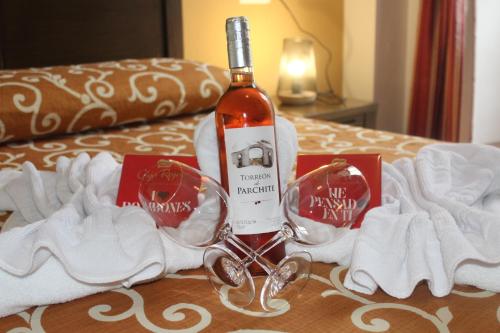 隆达Hostal San Cayetano的床上坐着一瓶葡萄酒